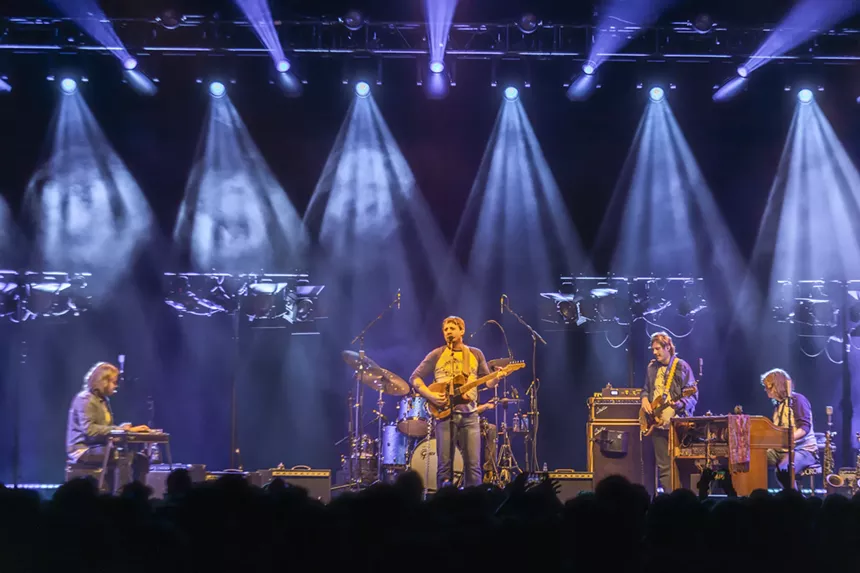 A photo of Sturgill Simpson on stage at Mission Ballroom with stage lights behind him.