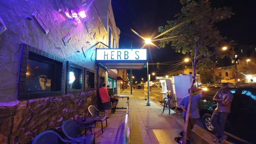 A building sign that reads "Herbs"
