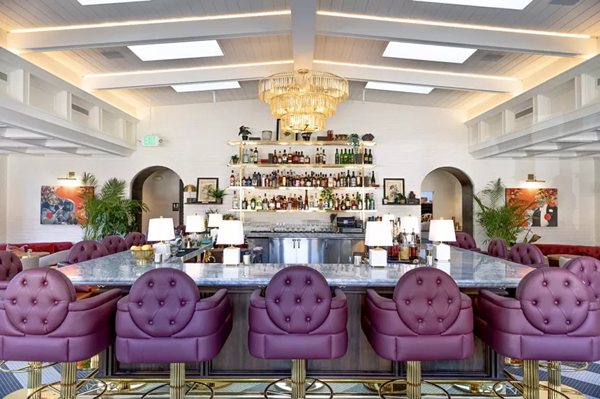 A cocktail bar with purple chairs