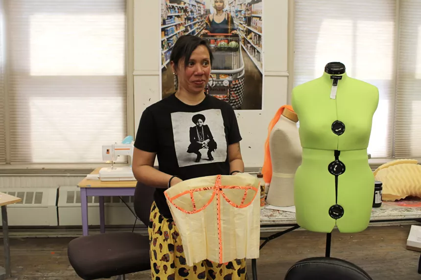 A woman holds a corset.