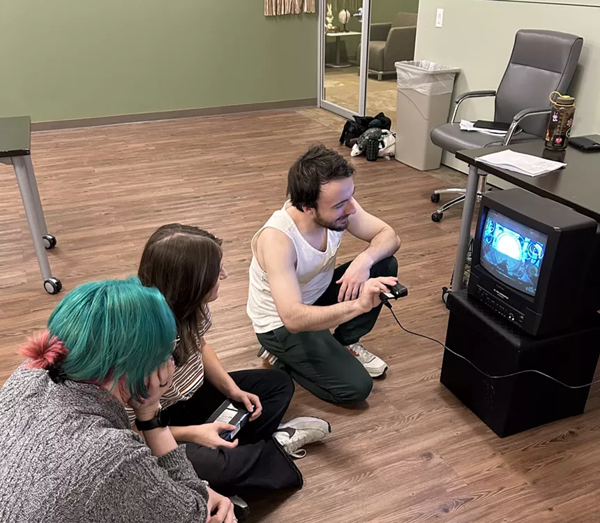 People sit in front of an old television.