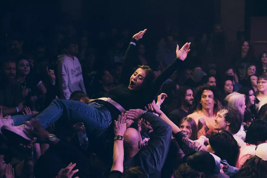 A photo showing a concertgoer crowd surfing during The Velveteers at the Bluebird Theatre.