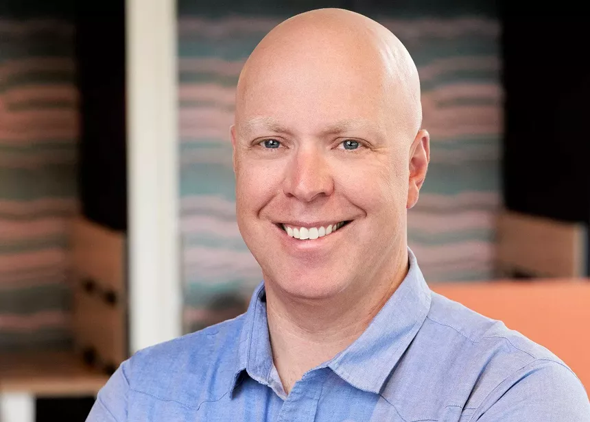 bald man in blue shirt