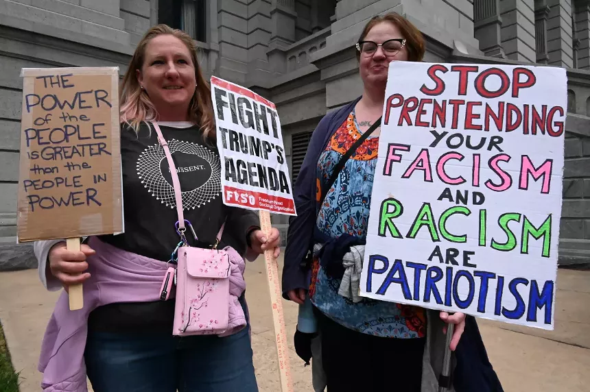 Women hold up signs.
