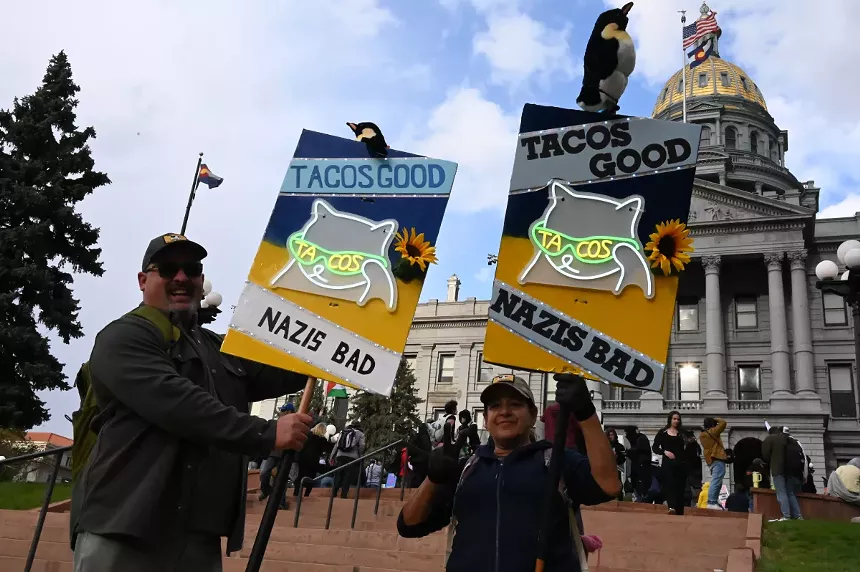 Protesters hold up signs in front of Capitol