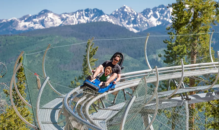 A man and young boy riding the mountain coaster at Vail Ski Resort