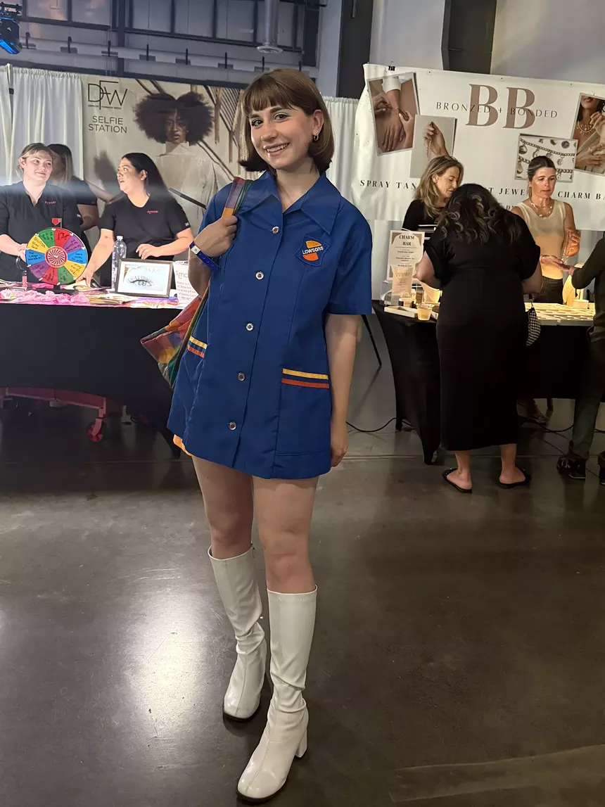 A woman in white boots and a blue dress