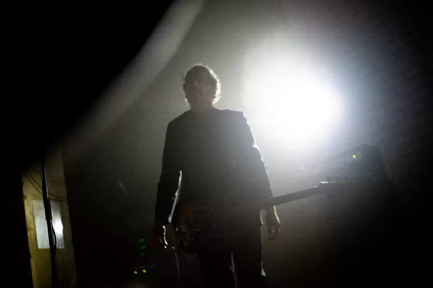 A silhouetted bass player