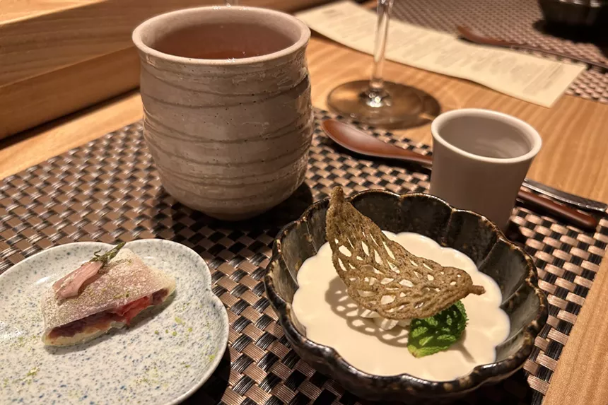 A cup of buckwheat tea alongside mochi and roasted green tea pudding
