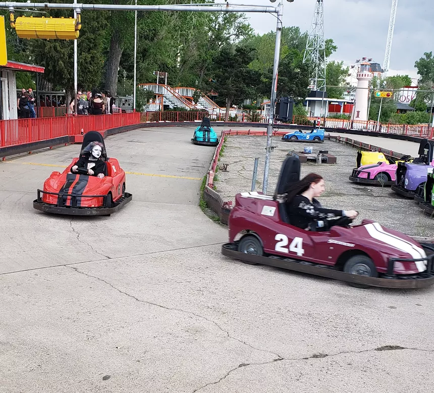 People in goth attire in race cars