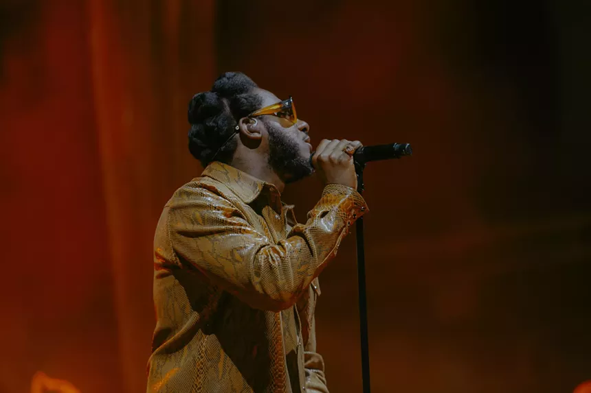 Leon Bridges on stage at Red Rocks with a red haze behind him.