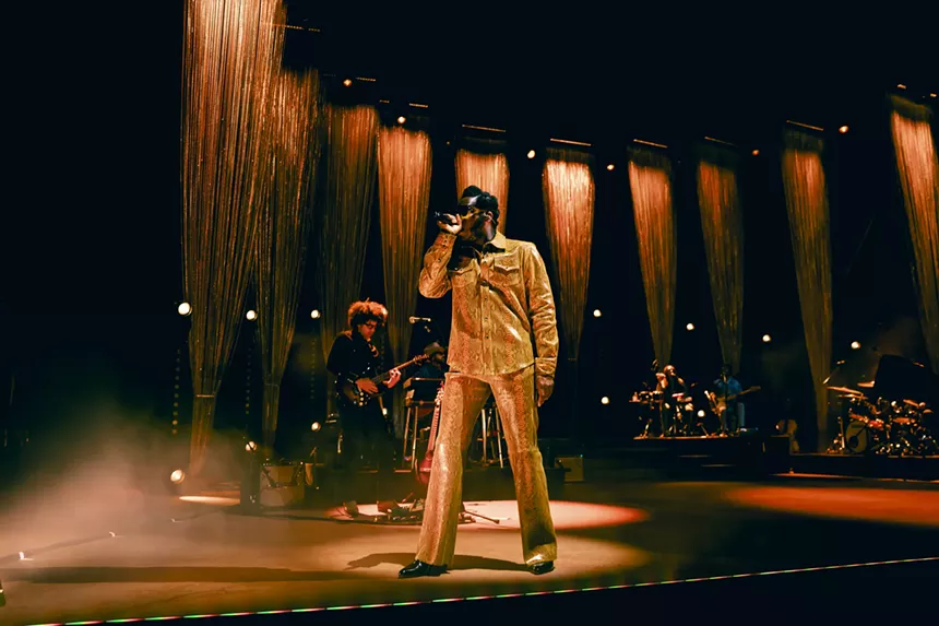 A photo showing Leon Bridges on stage at Red Rocks with his band behind him.