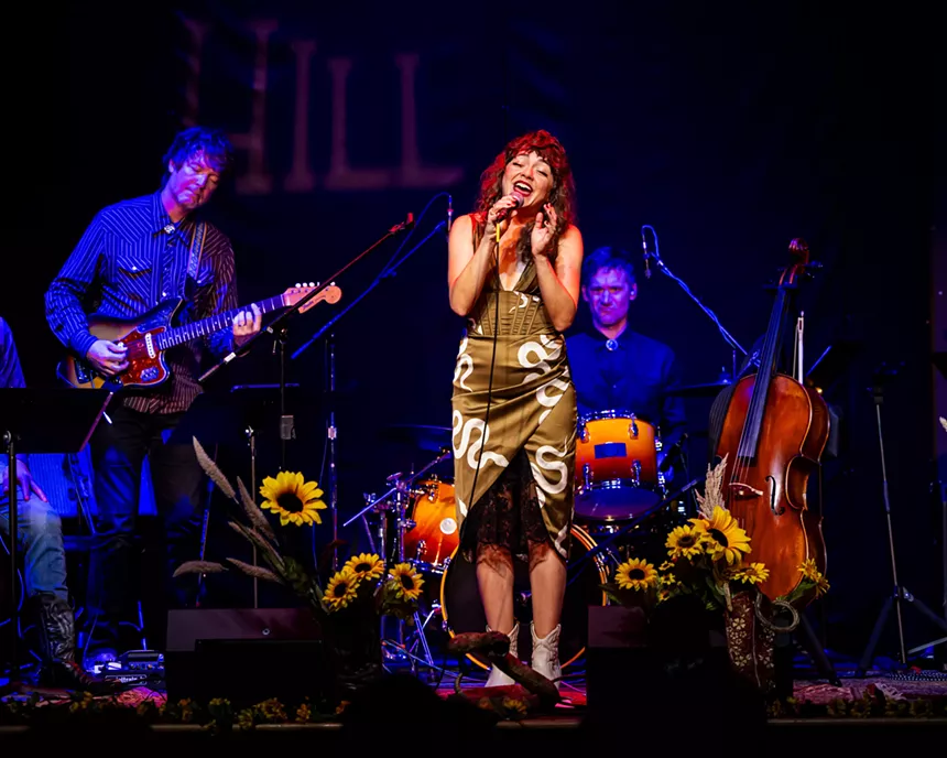 A woman sings on a colorful set