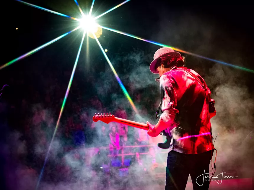 Todd Park Mohr playing guitar in a beam of light