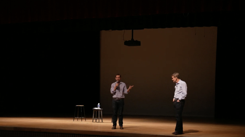 Men speak on stage