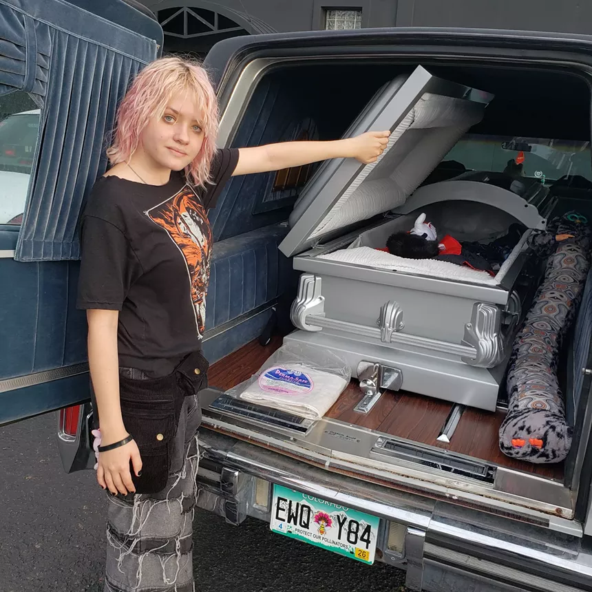 A person stands next to a hearse