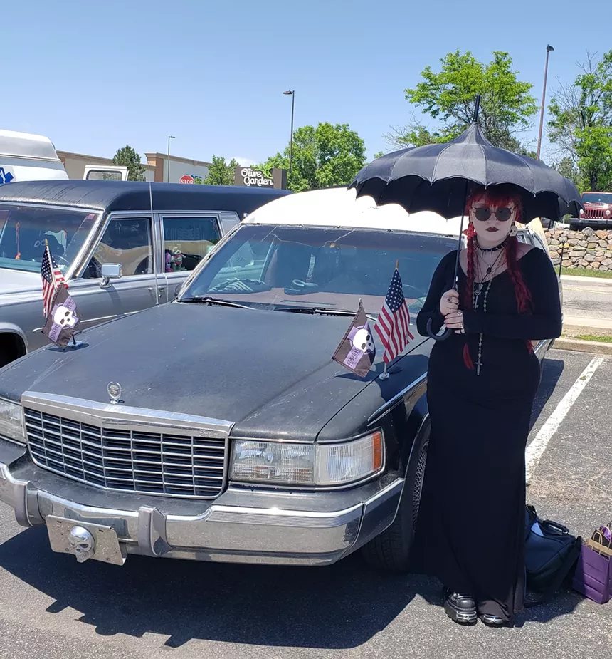 A person stands next to a hearse
