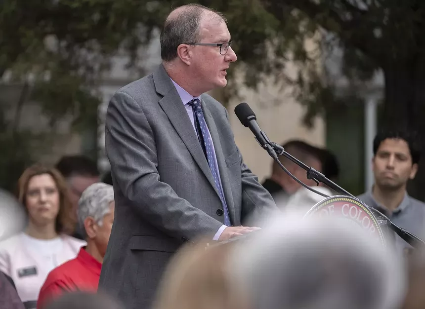 man at podium talkes to crowd