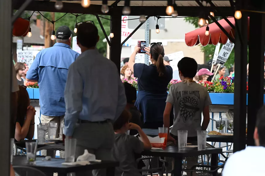 People watch a protest pass.