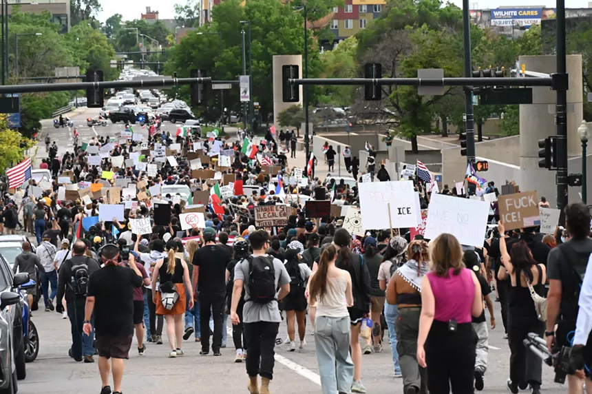 A throng of protesters walks down Lincoln Street.