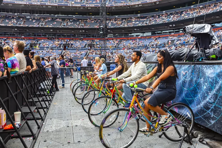 Fans help power the Coldplay concert by riding bicycles at Empower Field at Mile High.