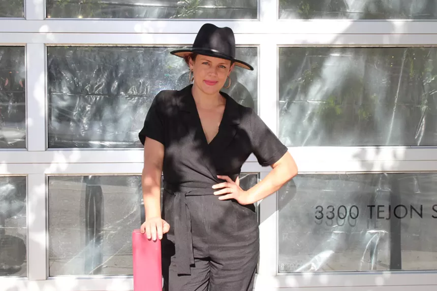 A woman poses outside.