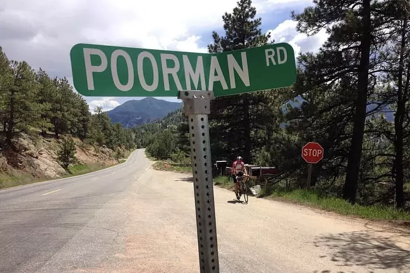 A green road sign reading Poorman Road