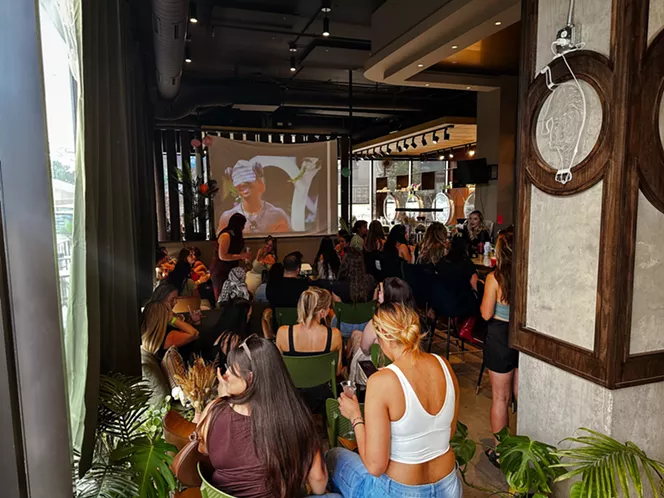 people gather to watch love island on a screen