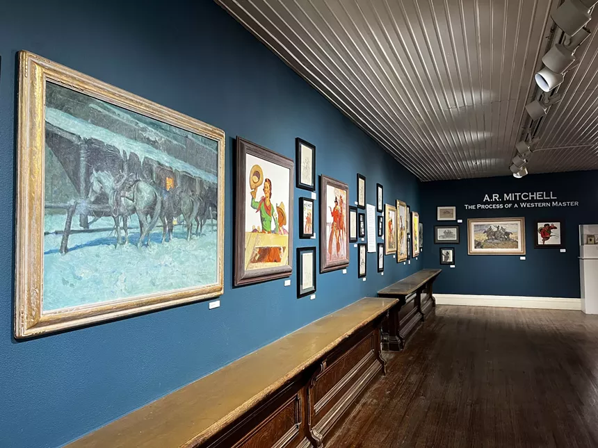 A blue wall with paintings