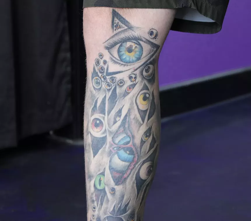 A leg with eyeball tattoos on it.