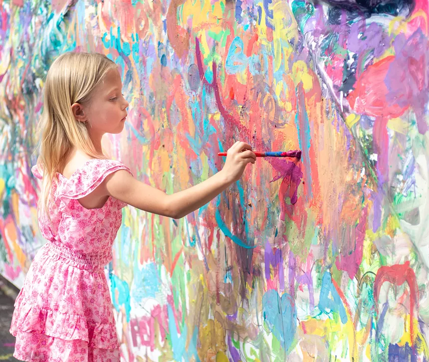 A girl paints a wall