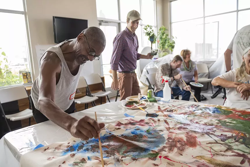 A man paints on a canvas