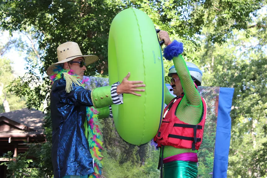 Two men hold a green inner tube.