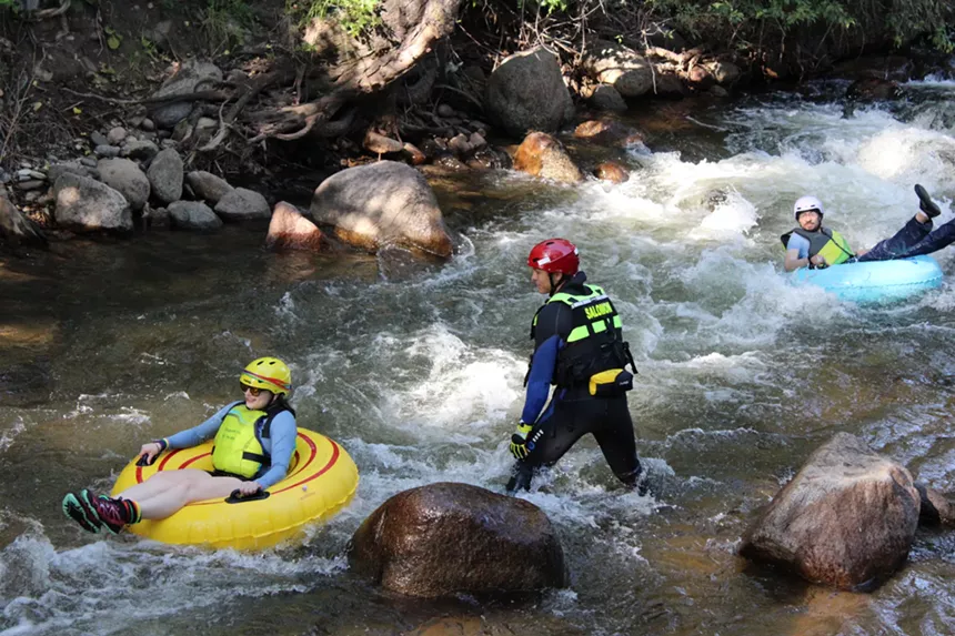 People float in a creek.
