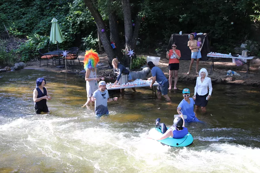 People hand out Bloody Marys to those floating in the creek.