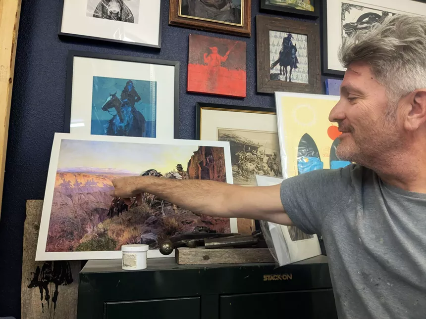 A man flips through colorful paintings