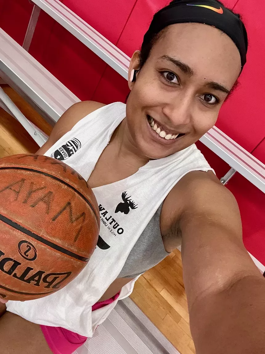 A woman holds a basketball