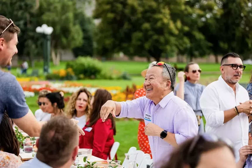 Two individuals moving to shake hands during a Longer Tables event