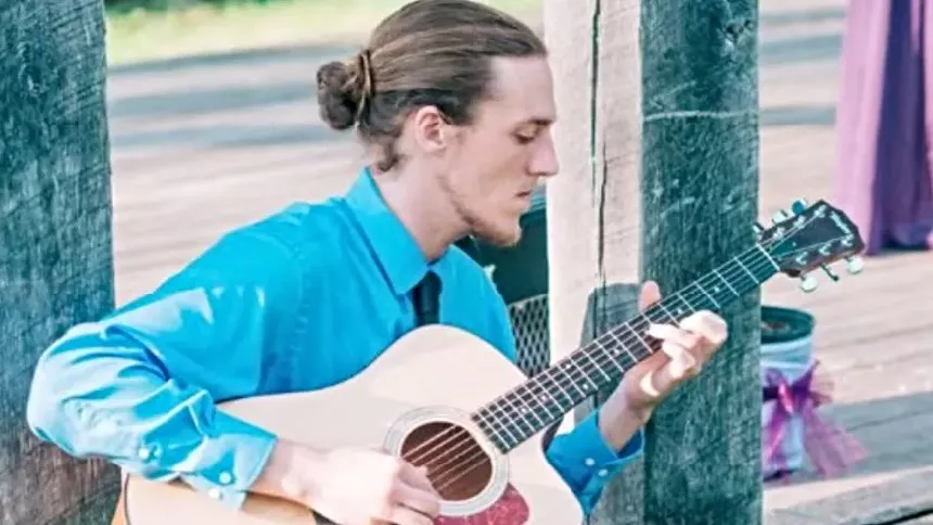 man plays acoustic guitar