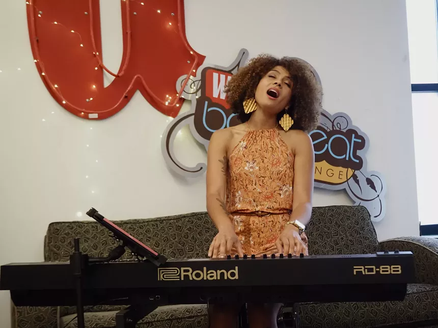 woman playing a piano and looking up