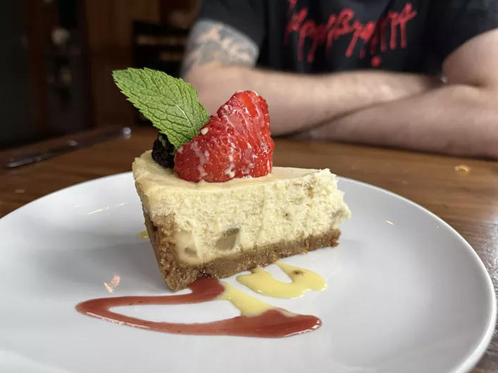 Cheesecake on a plate with a strawberry on top