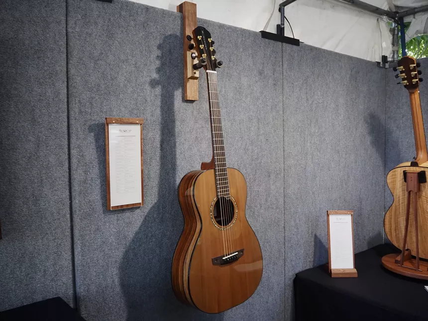 A guitar hangs on a wall