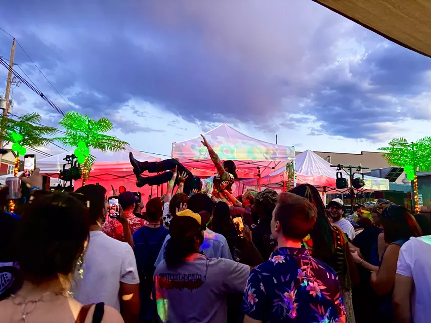 person crowdsurfing at an outdoor concert