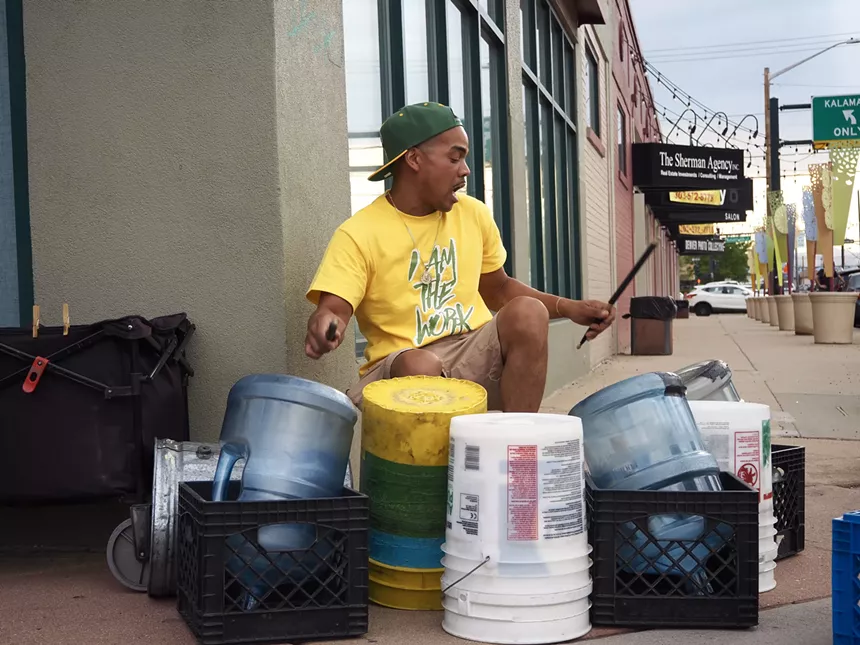 A man drums on plastic buckets