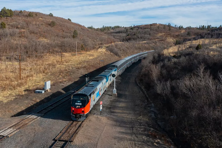 An aerial view of the Southwest Chief traveling past hills and bare trees