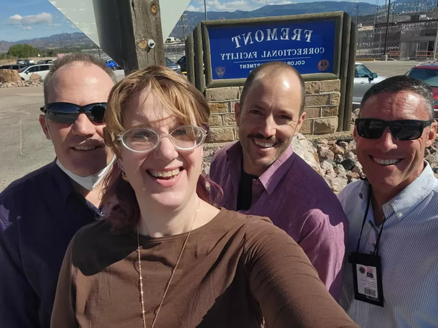 woman and three men outside prison