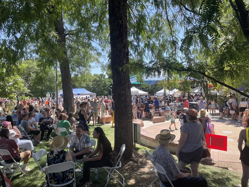 People mingle in the shade.