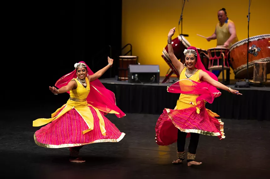 Dancers perform onstage.