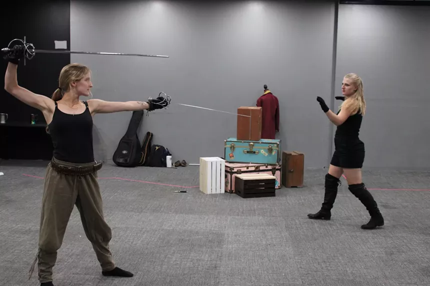 Two woman sword fight.