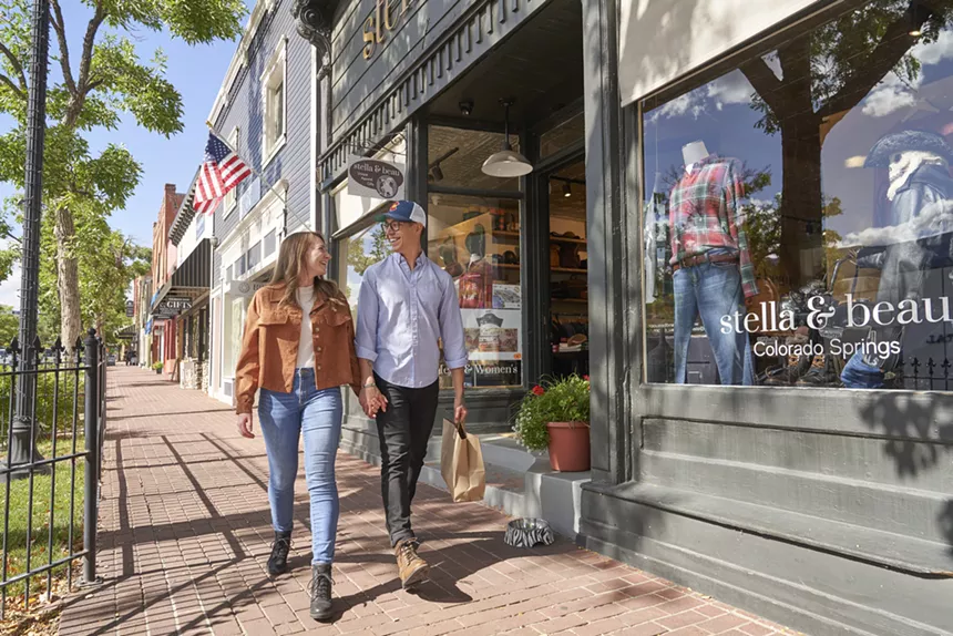 Two people walking past a boutique in Old Colorado City